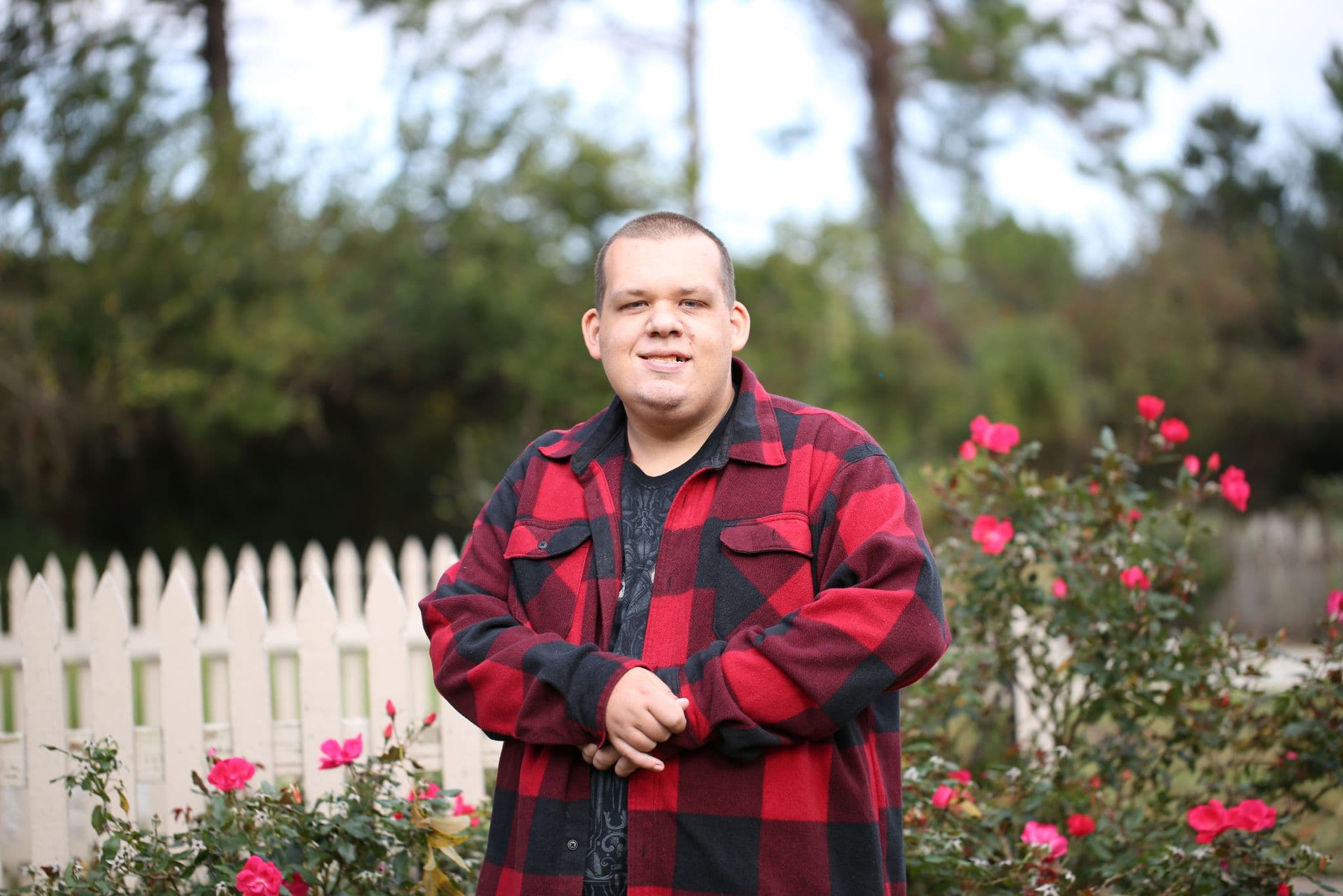 A young man supported by HomeCare Chesterfield smiling in a garden